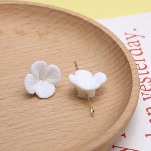 Macro-detail van witte keramische bloemkraal met centraal gat voor DIY-sieraden