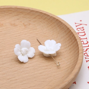Macro-detail van witte hars perzikbloesem kralen met metalen pinnen voor DIY sieraden maken