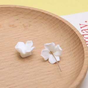Macro-detail van witte hars bloemkralen met matte afwerking en metalen pin voor DIY-sieraden