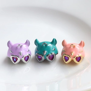Three cat-shaped enamel pendants with heart-shaped gemstone eyes in pastel colors