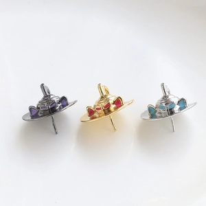 Macro shot of three cone-shaped metal pendants with colorful enamel in black, gold, and silver