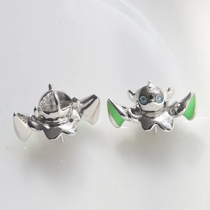 Detailed view of 3D winged monster charms with polished silver finish and green enamel details