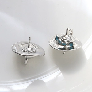 Detailed view of silver sombrero stud earrings with blue-green enamel decorative coating