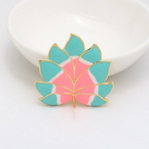 Detailed leaf pendant with gold plating and blue and pink enamel finish on white background