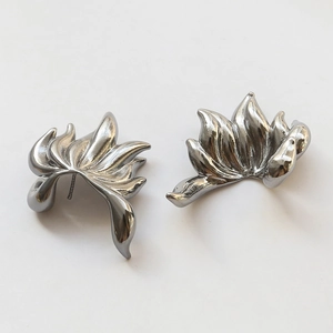 Macro shot of silver-colored flame-shaped earrings with a polished metallic finish