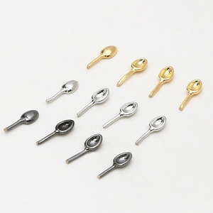 Detailed view of 12 miniature metal spoon charms in gold, silver, and gun black finishes