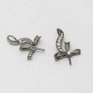 Detailed close-up of gunmetal bow-shaped jewelry charms with white zircon inlay settings