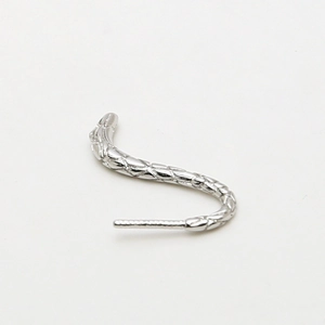 Close-up of silver S-shape earring with intricate scale texture and shiny metallic finish
