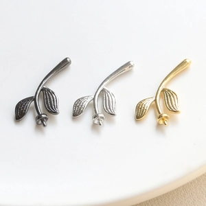 Detailed trio of leaf-shaped jewelry pendants with pearl trays in gold, silver, and black