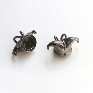 Detail of black Jester hat earrings with high-gloss finish and gothic copper-gold plating