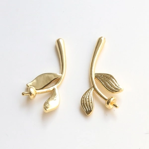 Macro view of gold-plated leaf branch pendants with pearl cup bases for DIY jewelry