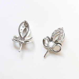 Macro shot of silver hollow leaf jewelry charms with white zircon stone setting