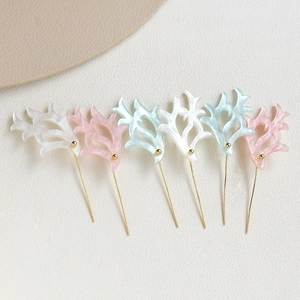 Close-up of handmade antler acetate pins with pearl texture and gold accents