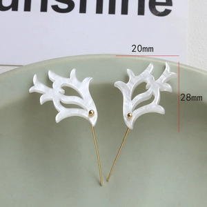 Detail of white acetate antler charms with pearl luster and golden pins, size 20mm x 28mm