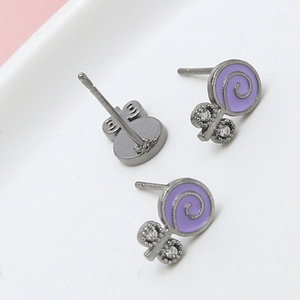 Gros plan de boucles d'oreilles sucettes violettes avec zircons et motif en émail