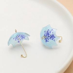 Detail of light blue floral ghost umbrella earrings with gold alloy hooks and bead accents