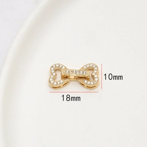 Détail macro du fermoir bijou nœud doré 18x10mm serti de pierres de zircone cubique