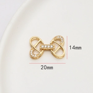 Détail d'un fermoir à bijoux en forme de nœud doré avec des pierres de zircon