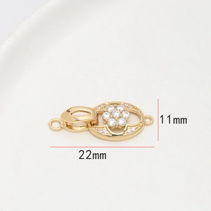 Gros plan d'un fermoir de bijoux doré de 11x22mm avec fleur en cristal et dimensions
