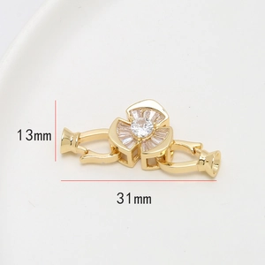 Détail macro du fermoir fleur plaqué or avec zircons et dimensions de 31 mm