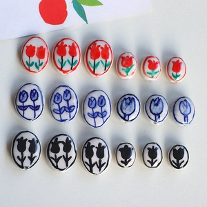 Macro detail of hand-painted ceramic tulip beads for DIY jewelry making in various colors