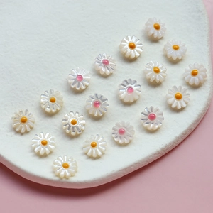 Détail de perles de marguerite sculptées avec centres colorés pour création de bijoux DIY
