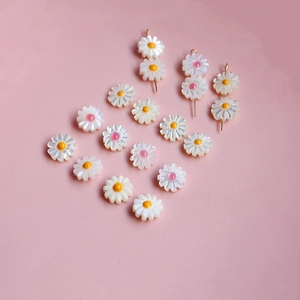 Détail de perles marguerites en nacre sculptées main pour création de bijoux DIY élégants
