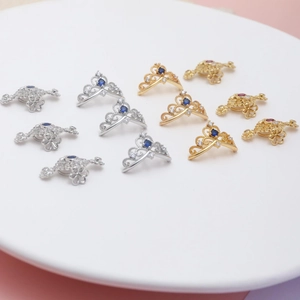 Macro shot of gold and silver plated crown and pumpkin carriage charms with cubic zirconia