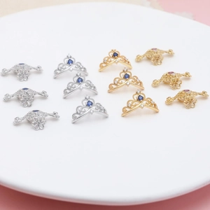 Detailed macro view of gold-plated crown and floral charms with colorful cubic zirconia
