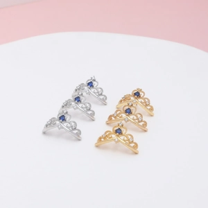 Macro view of gold and silver crown rings with blue zircons and intricate filigree details