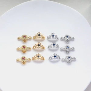 Macro shot of 12 crown-shaped gold and silver pendants with colorful zircon inlays