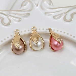 Vista macro di ciondoli a forma di perla in oro, bianco e rosa con cornici floreali