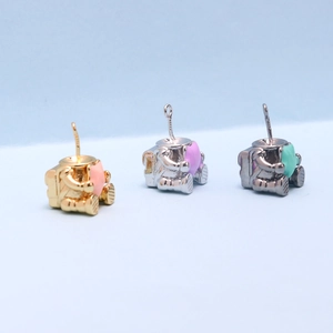 Detailed view of astronaut-shaped DIY jewelry pendants in gold, silver, and black metal