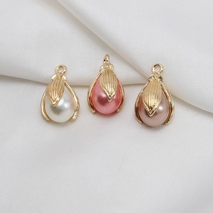 Dettaglio di pendenti in perle a goccia con cappucci dorati in bianco, rosa e champagne