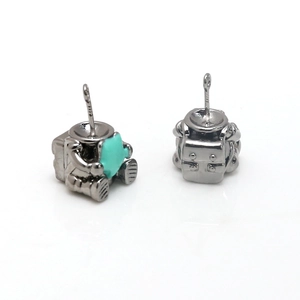 Detail of silver astronaut pendants with blue star accent and back view of metal texture