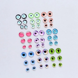 Flat lay of multiple sized glass evil eye cabochons for DIY jewelry and doll making