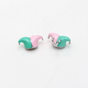 Macro detail of enamel jester hat charms in pink and green with silver metal plating
