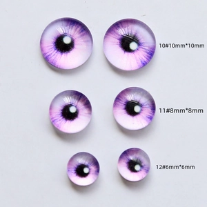 Macro detail of purple glass demon eyes in three sizes for DIY doll making crafts