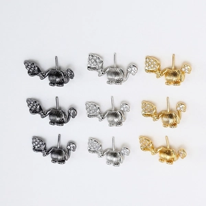 Detalle de pendientes de elefante con circonitas pavimentadas en oro, plata y metal negro