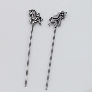 Detalle macro de colgantes de unicornio con circonitas y reverso de metal hueco