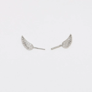 Detail of silver wing-shaped jewelry charms featuring intricate feather engraving