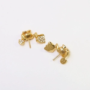 Vista detallada de pendientes vintage bañados en oro con dijes de corazón y cristales