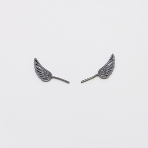 Macro detail of dark silver wing-shaped metal studs with intricate feather texture