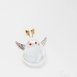 Detailed view of Baroque pearl insect charm with silver filigree wings and gold accents