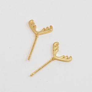 Detail von goldenen Geweih-Ohrsteckern mit Zirkonia-Steinen im minimalistischen Stil