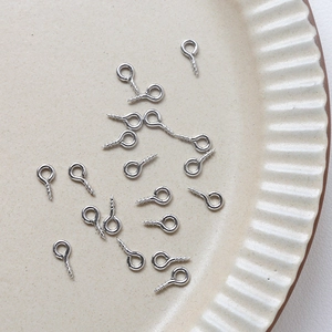 Gros plan d'attaches à vis argentées pour la création de bijoux faits main et DIY