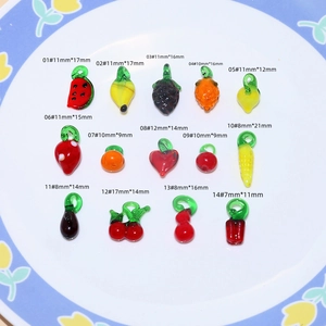 Macro shot of 14 colorful handmade glass fruit and vegetable charms in a ceramic plate