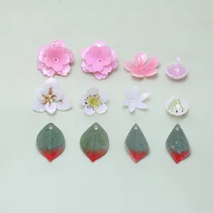 Flat lay of textured floral petals and leaf charms for DIY jewelry making accessories