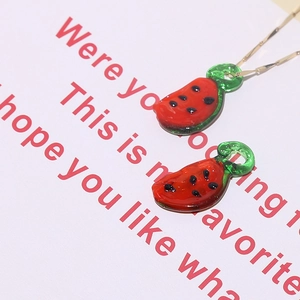 Detailed view of handmade glass watermelon charms with a delicate gold chain necklace