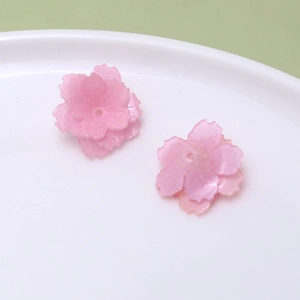 Detailed macro view of pink translucent cherry blossom resin petals for DIY crafts